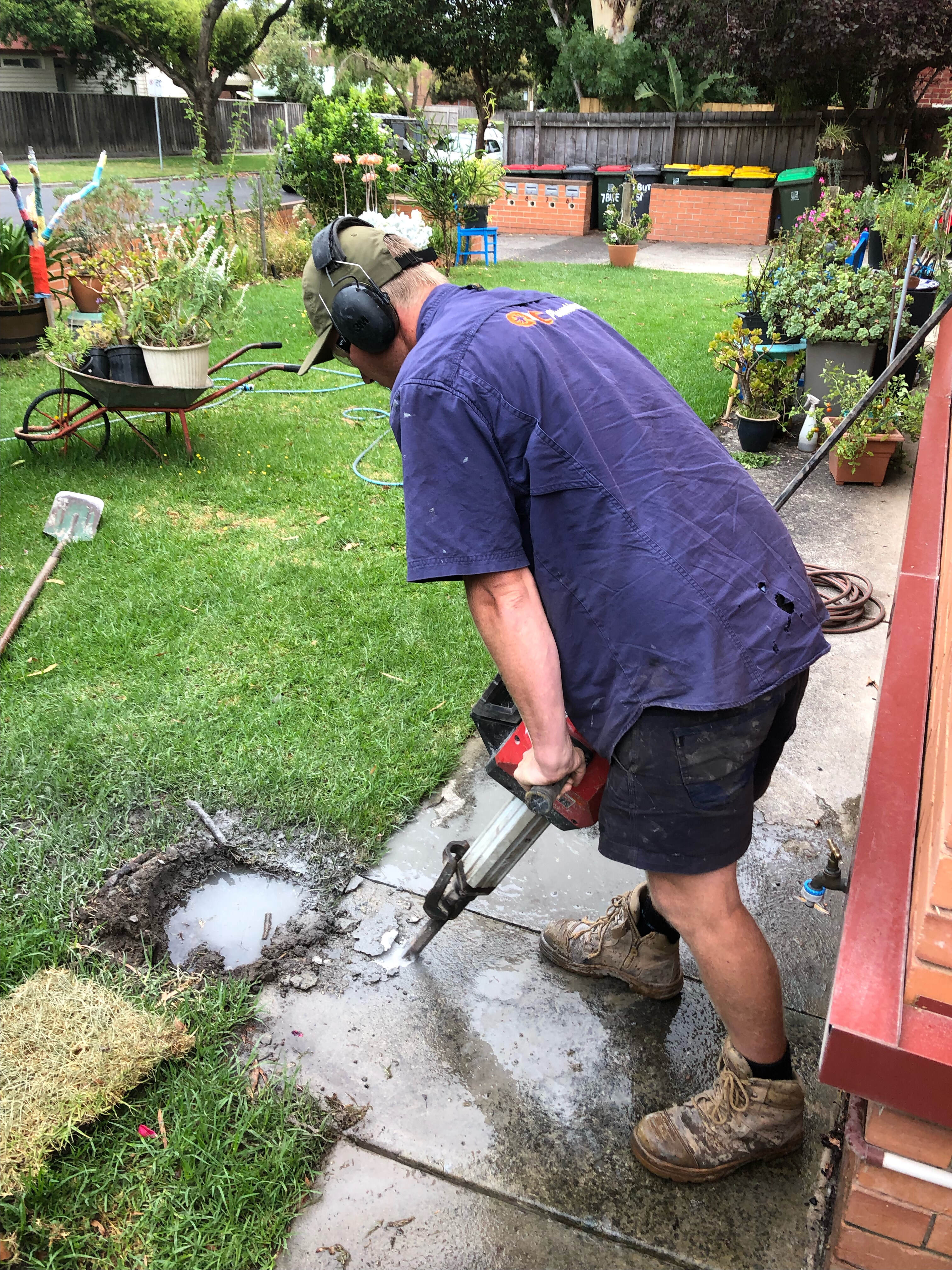 Breaking up concrete path to get to burst pipe under